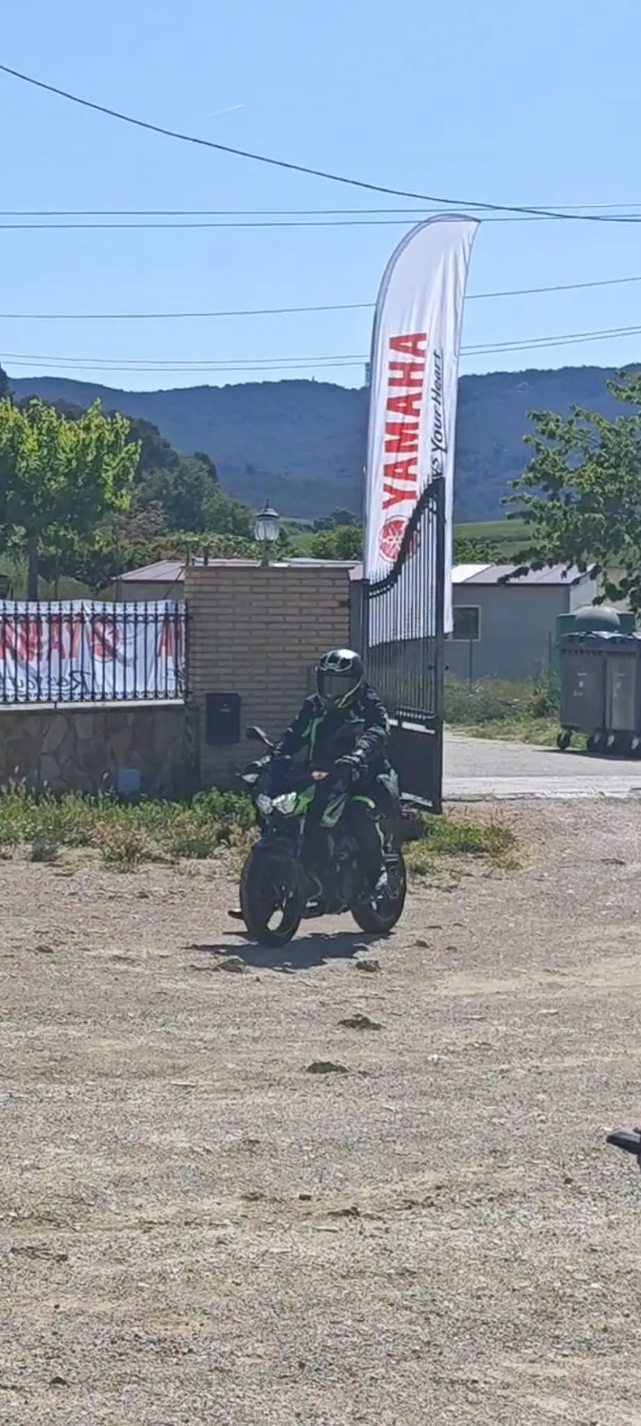 Un motorista amb casc arribant a l’entrada del Mas Pla