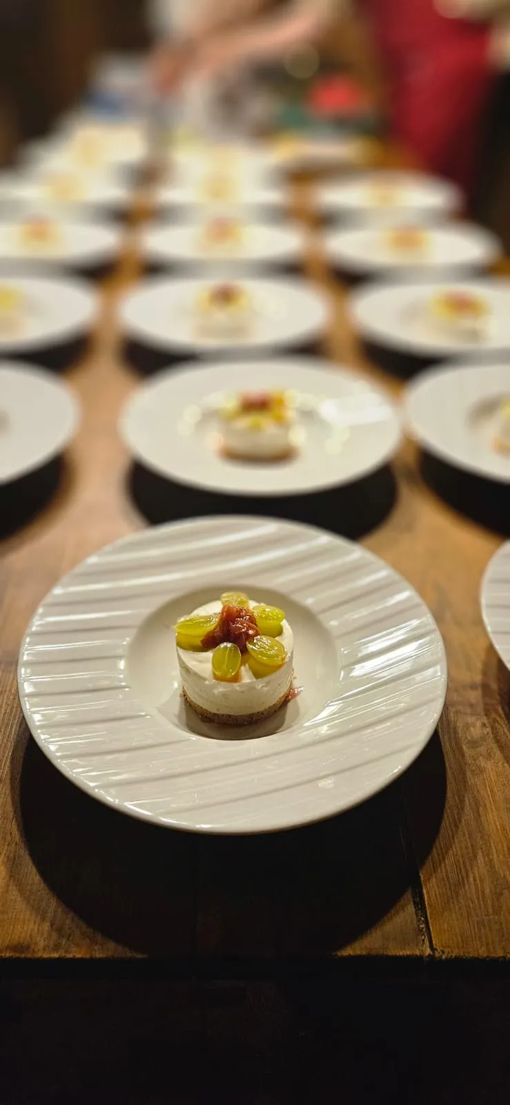 Pastís de formatge individual amb raïm i melmelada, en una filera de plats