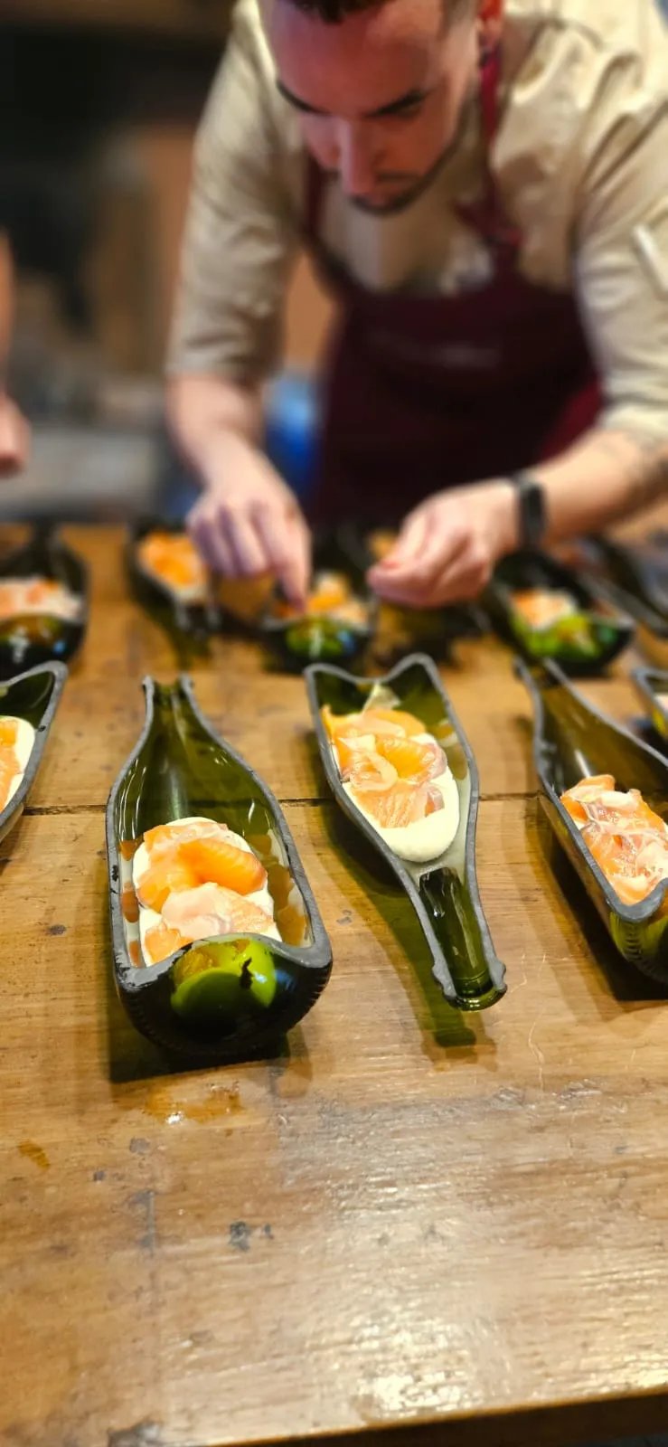 El xef acabant plats de salmó servits dins ampolles de vidre tallades